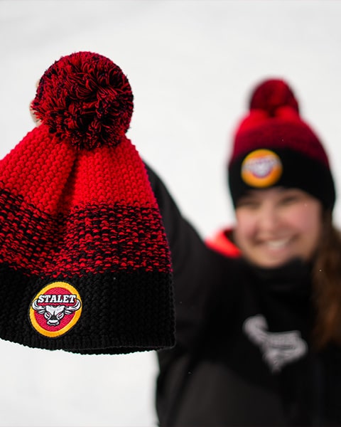 Girl shows the Stalet Cap, with the snow-capped mountains of Livigno in the background