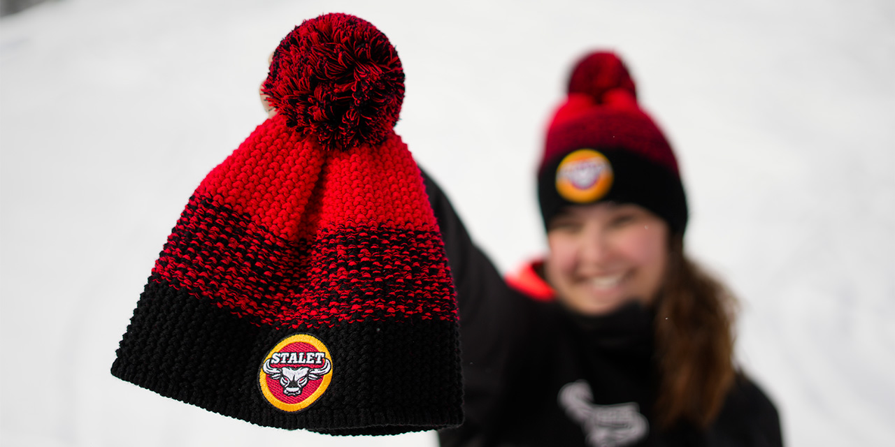 Girl shows the Stalet Cap, with the snow-capped mountains of Livigno in the background